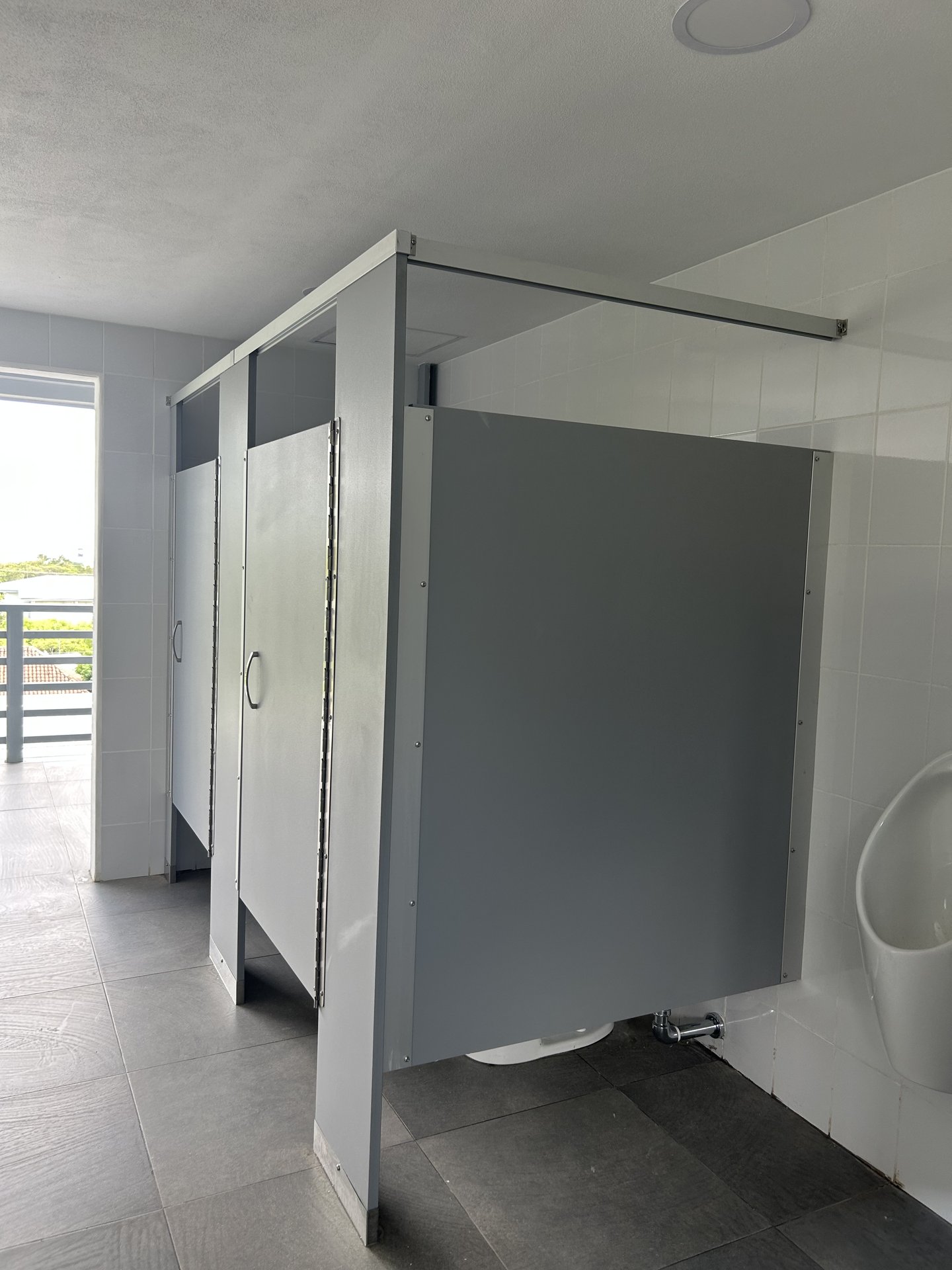Puertas de cubículos sanitarios con cerrojos institucionales en Edificio Copérnico