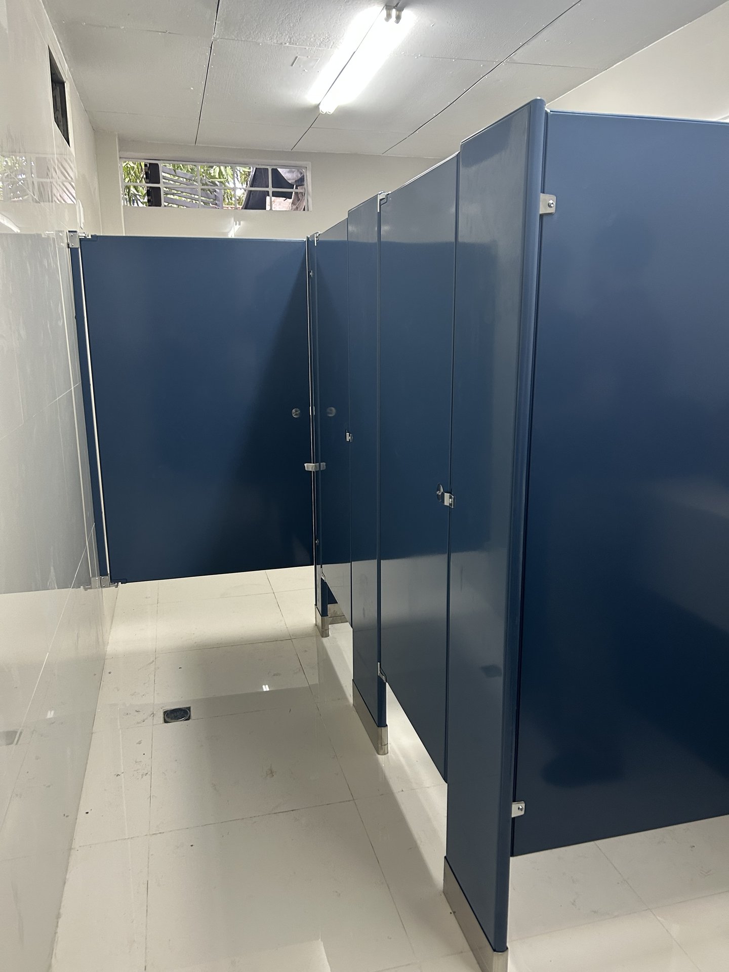 Particiones sanitarias esmaltadas azul marino con fijación reforzada a piso y techo