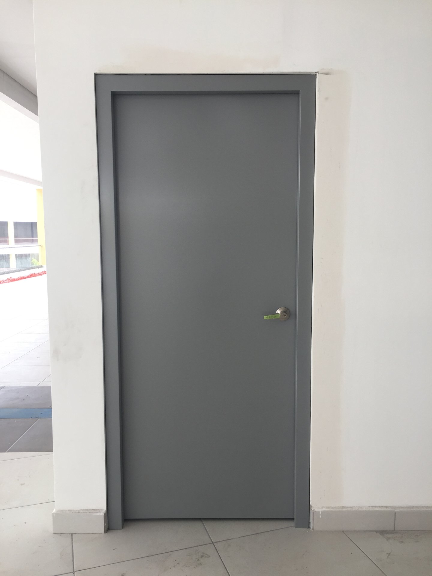 Puerta de acero instalada con marco envolvente en pasillo comercial Plaza Natura